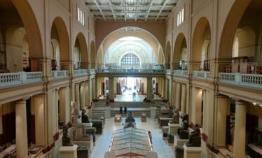 Wide view of the Egyptian Museum's main hall showcasing ancient sculptures and architecture.